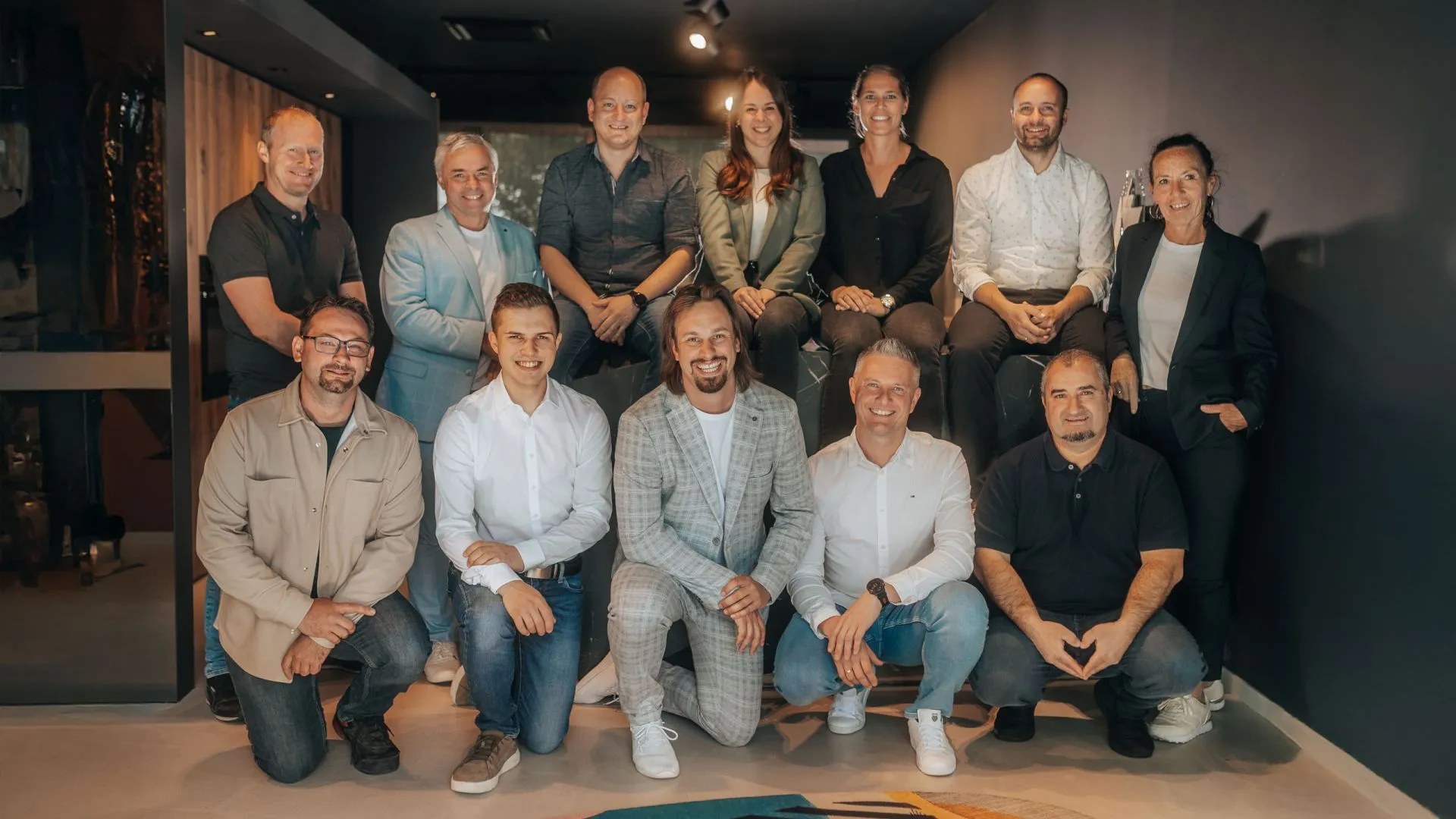 Das Team von Raumkonzept Halbmayr vor einer dunklen Holzwand