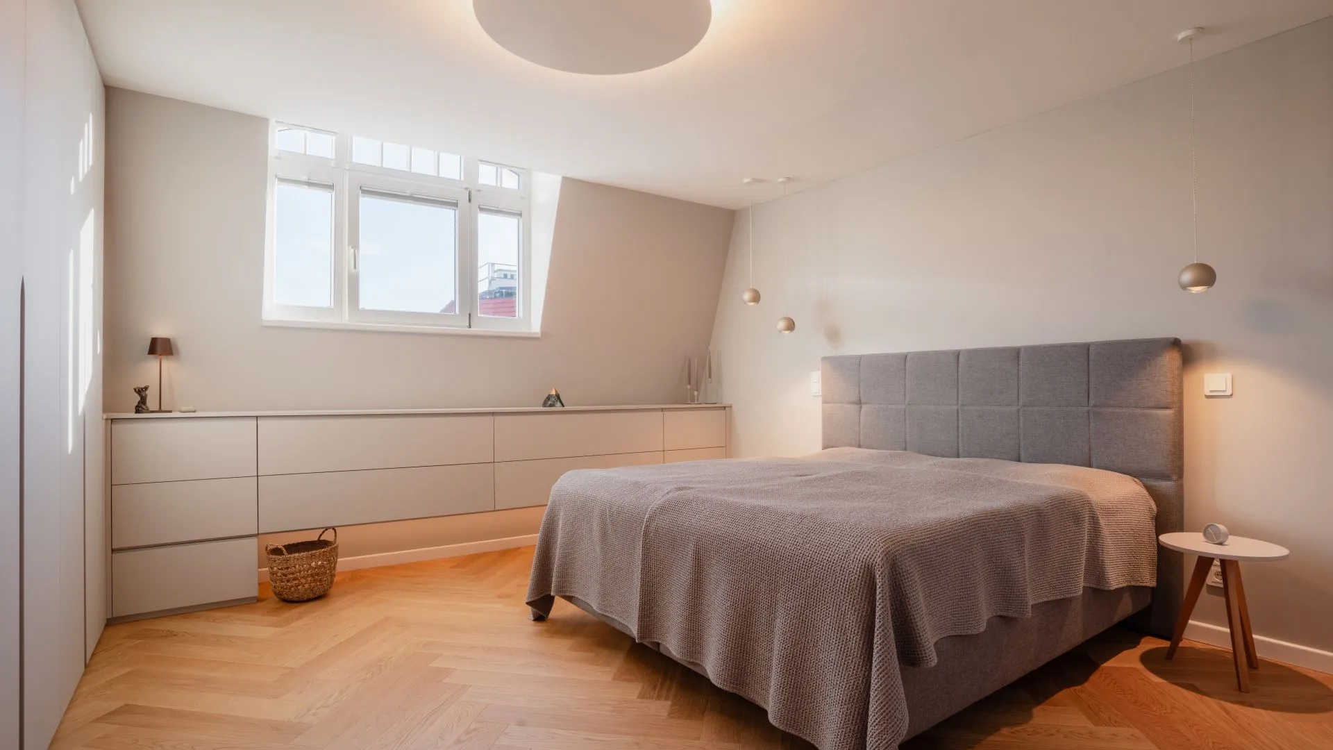 Schlafzimmer unter der Dachschräge mit Bett und Schrankwand