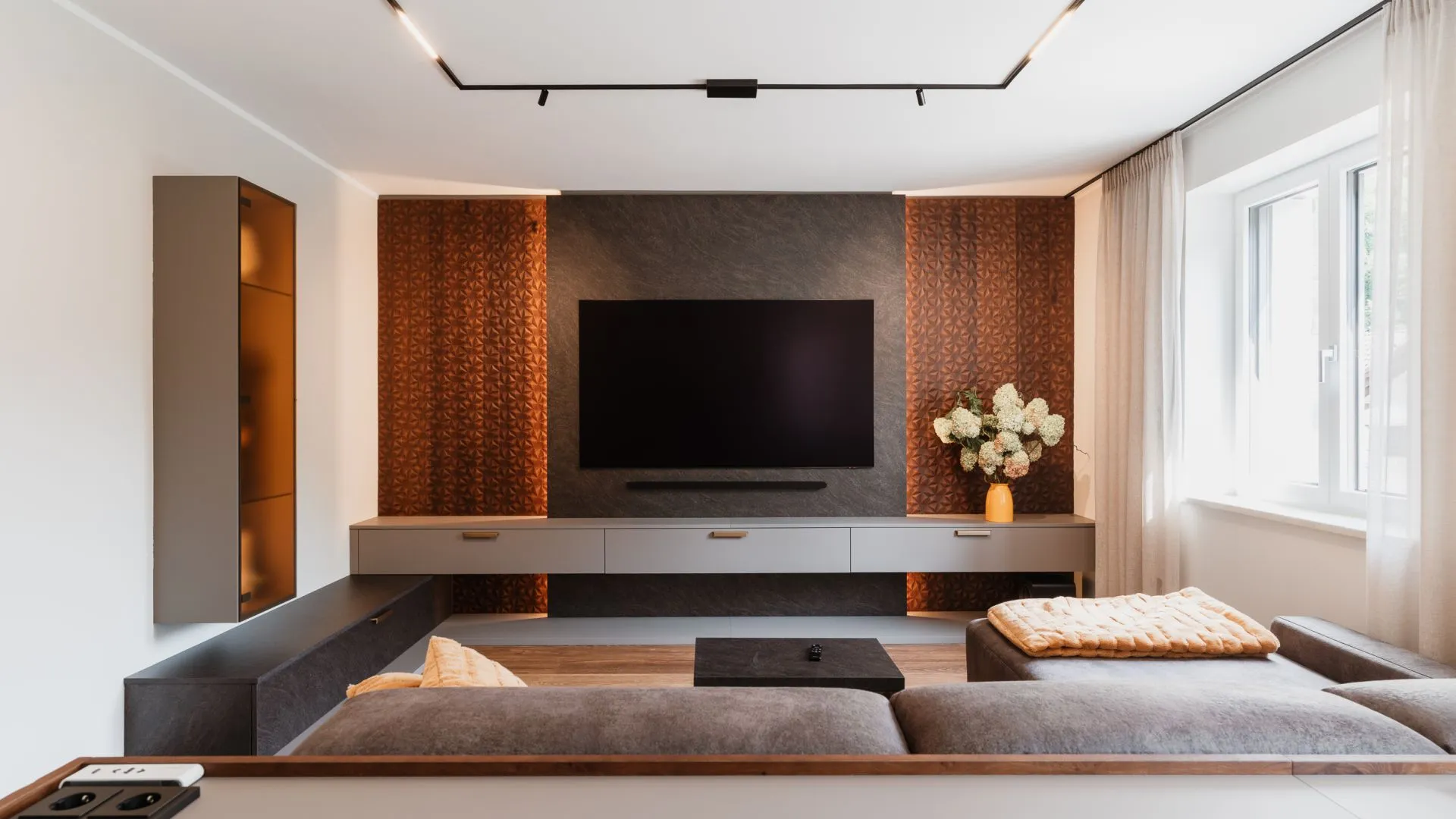 Wohnzimmer mit Medienwand, gemusterter Rückwand und Sofa