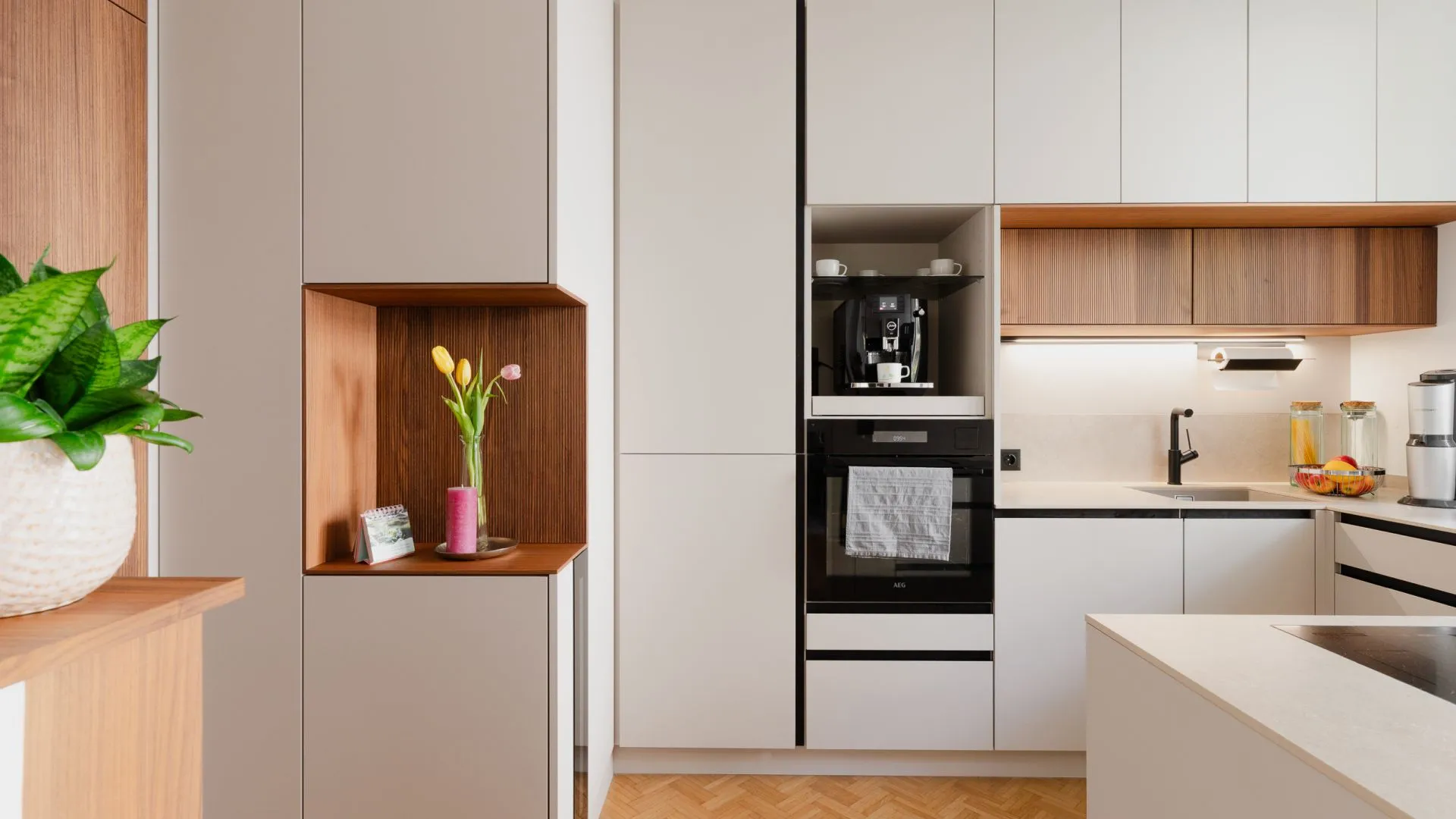 Hochwertige Küche mit hellen Fronten und warmen Holzdetails durchdacht geplant in kleinem Raum.