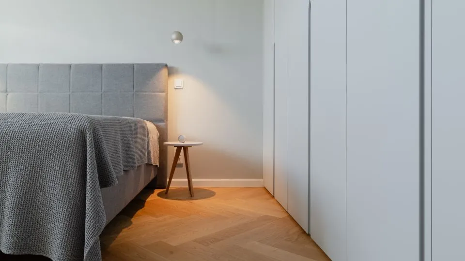 Doppelbett mit Polsterkopfteil neben raumhohem Einbauschrank