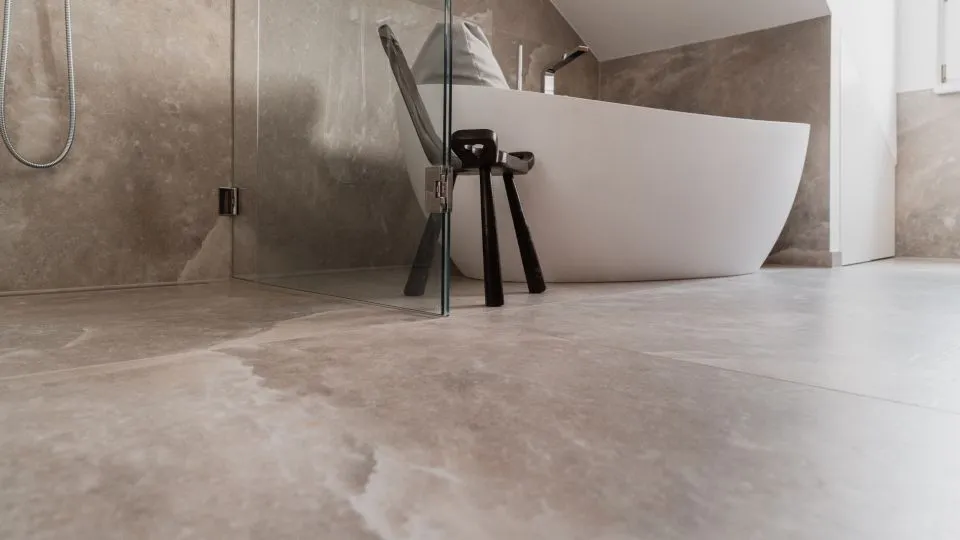 Freistehende Badewanne vor Steinwand unter der Dachschräge