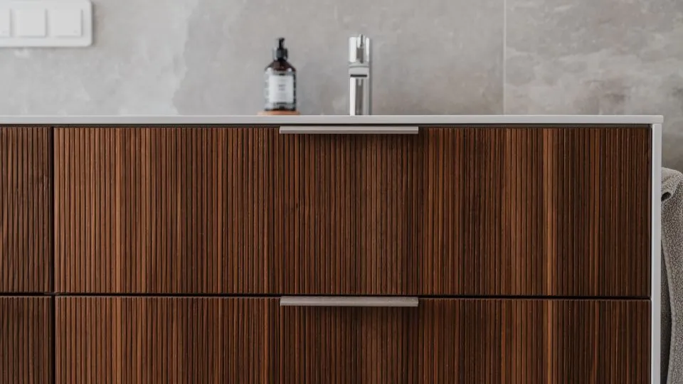Waschtischunterschrank aus dunklem Holz im Detail