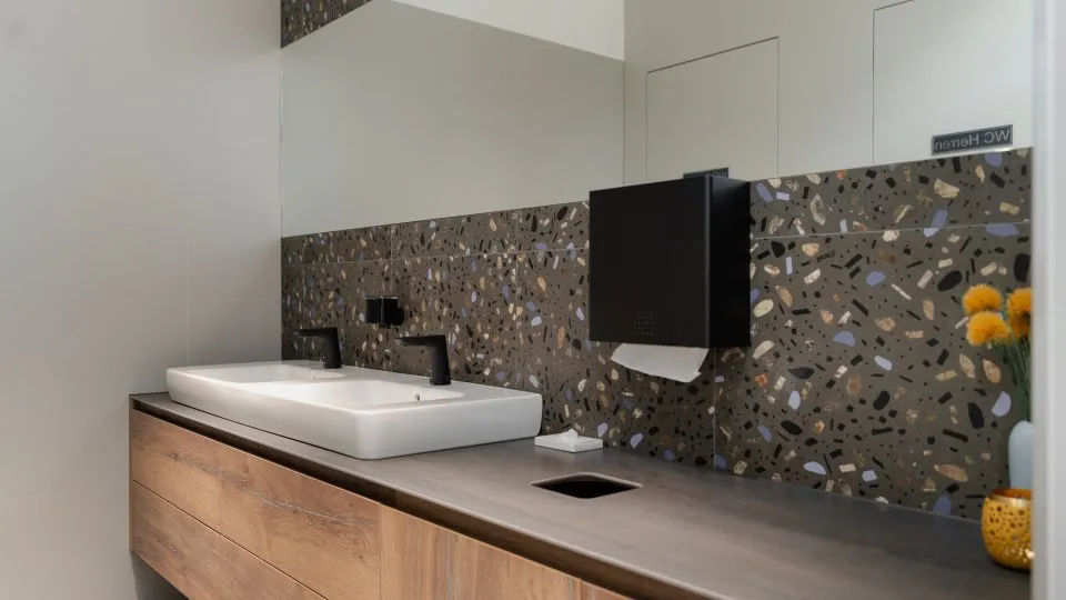Doppelwaschtisch aus Holz vor Terrazzo-Wand
