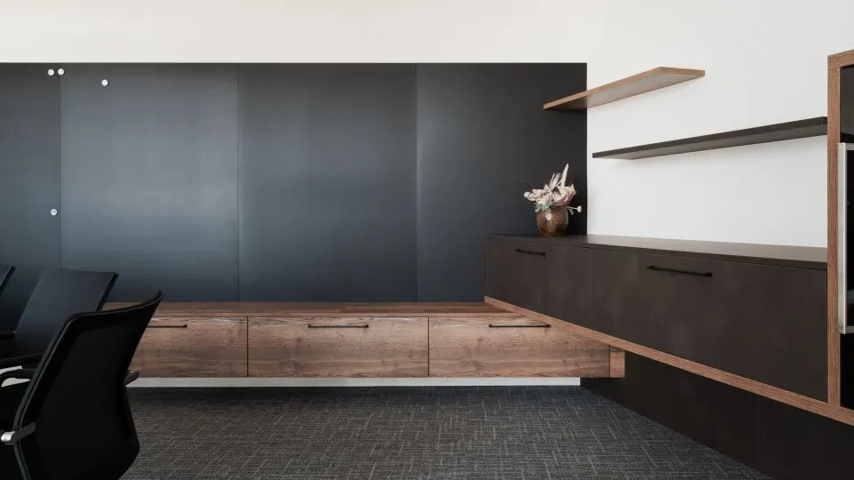 Besprechungsraum mit dunklem Sideboard und Pflanze