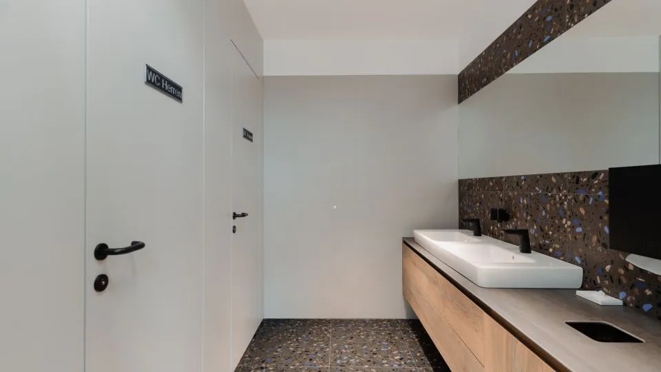 Sanitärbereich mit Waschtisch aus Holz und Terrazzo-Wand