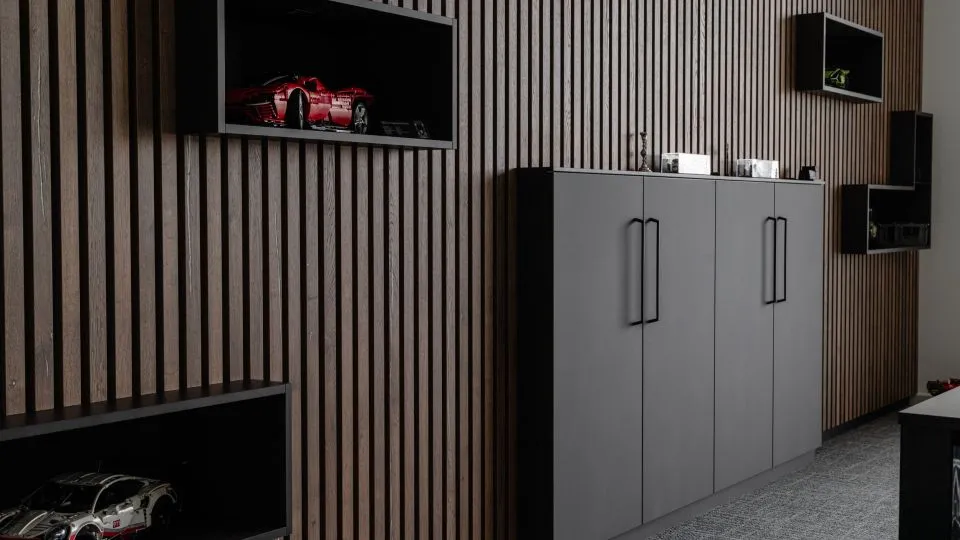 Schrankwand mit Holzlamellen und beleuchteten Vitrinen für Modellautos