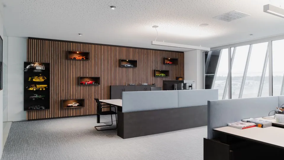 Büro mit Holzlamellenwand, Vitrinen und Arbeitsplätzen