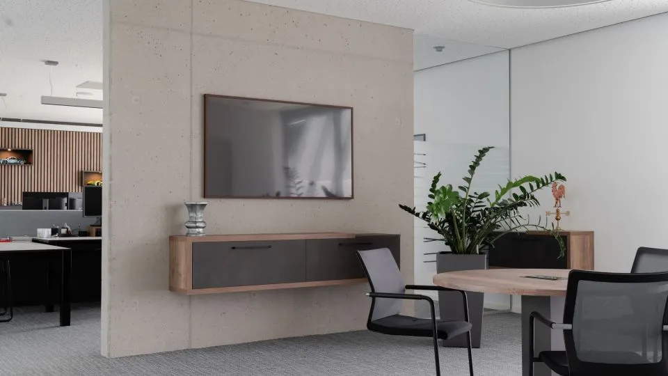 Besprechungsbereich mit Bildschirm an Betonwand und Sideboard