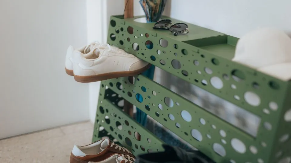 Grünes Schuhregal aus Lochblech mit Sneakers