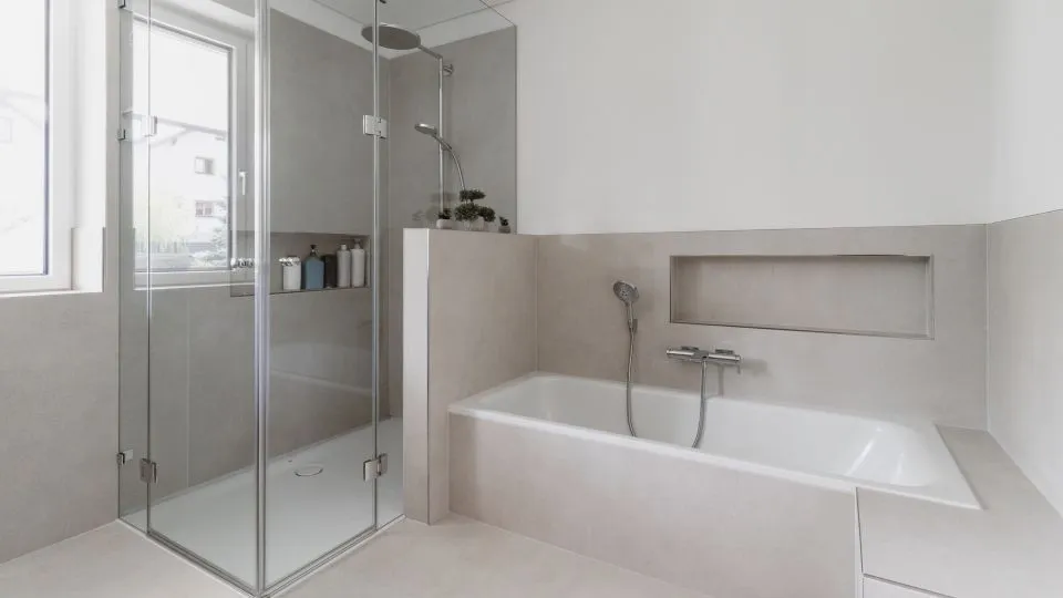 Badezimmer mit Dusche, Badewanne und Ablagenische