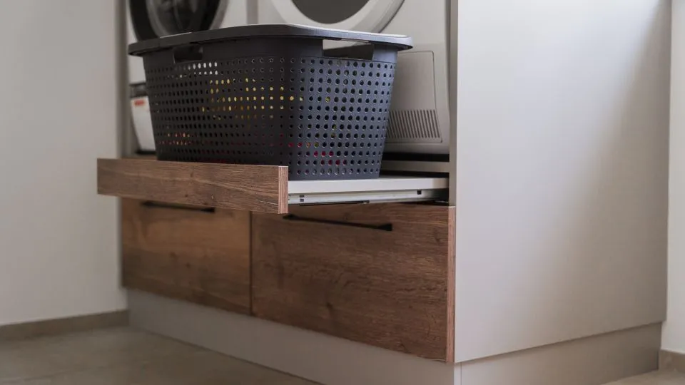Ausgezogene Schublade mit Wäschekorb in einem Hochschrank