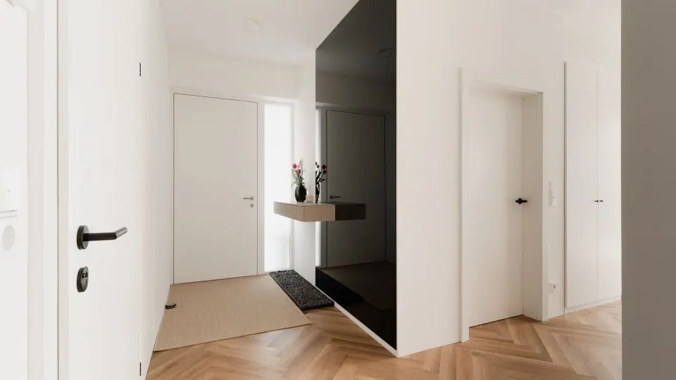 Heller Flur mit weißen Türen und Blick in den Eingangsbereich