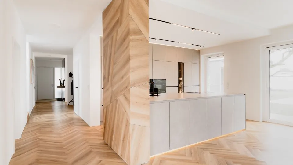 Flur mit Holzverkleidung und Blick auf die Kücheninsel