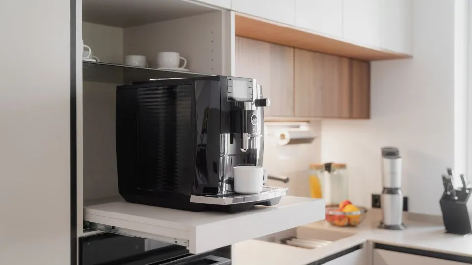 Kaffeevollautomat auf ausziehbarer Ablage im Hochschrank