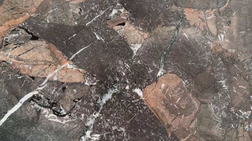 Nahaufnahme einer Natursteinplatte mit rotbrauner Maserung