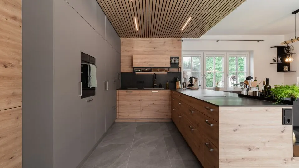 Küche in L-Form mit Holzfronten, Fenster und offenen Wandregalen