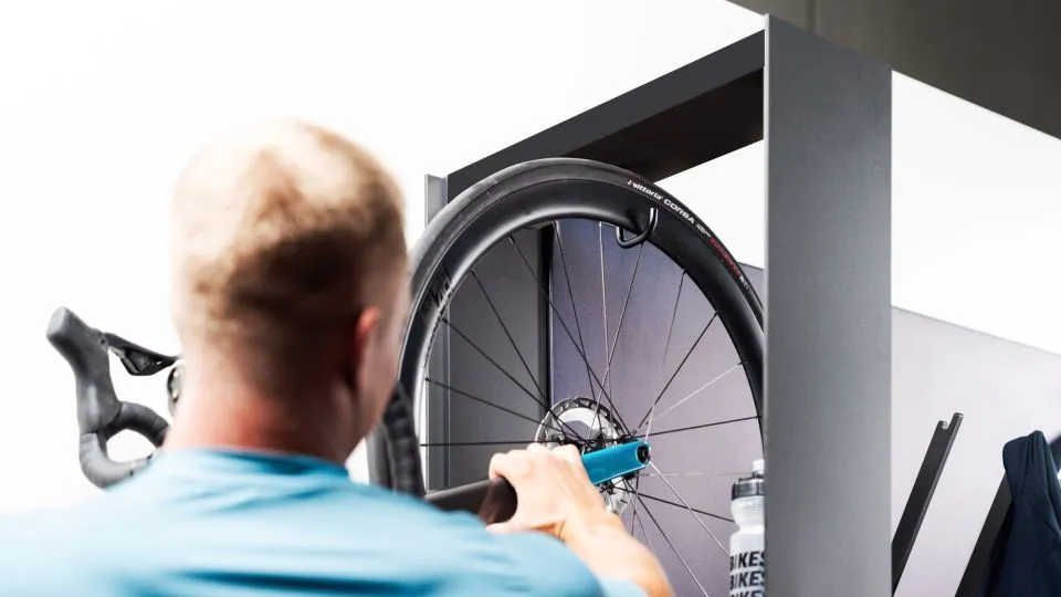 Person hängt ein Rennrad in eine Wandhalterung