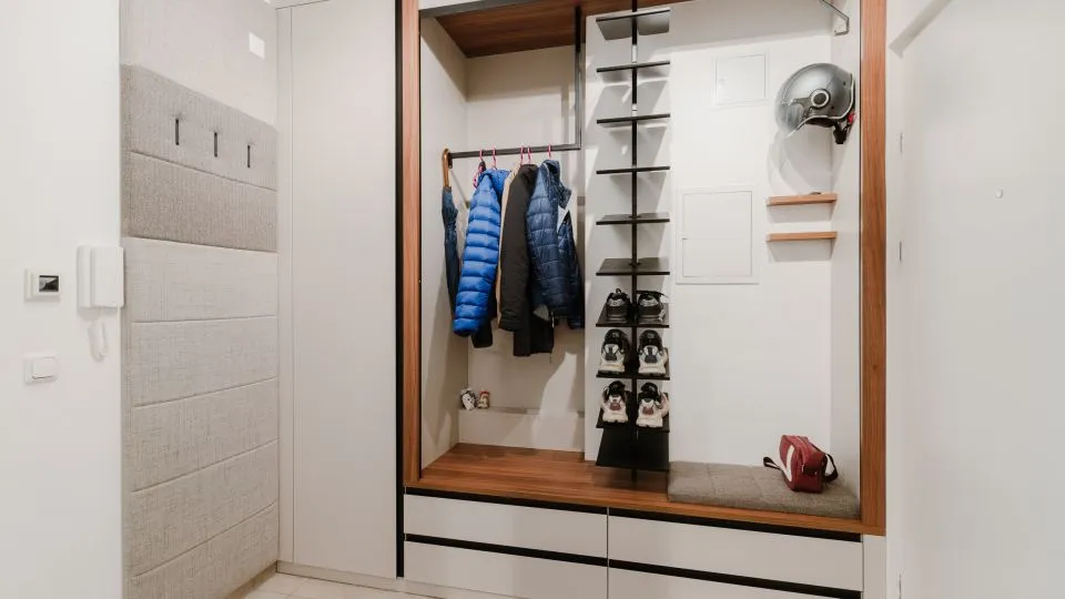 Vorzimmer mit geöffneter Garderobennische, Jacken und Schuhregal