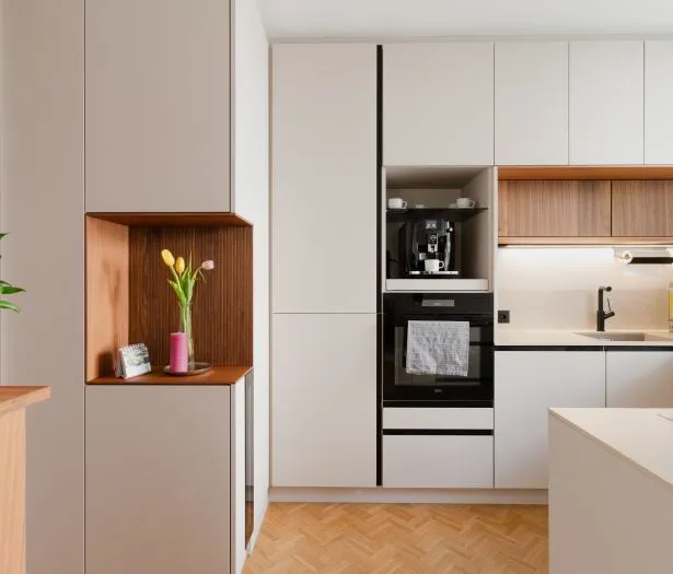 Hochwertige Küche mit hellen Fronten und warmen Holzdetails durchdacht geplant in kleinem Raum.