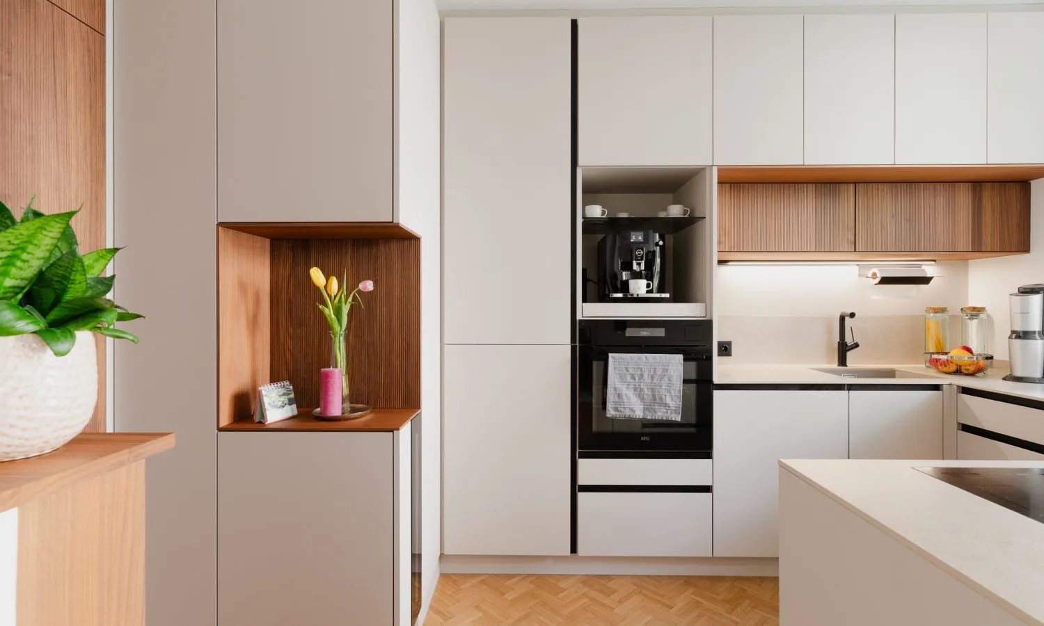 Hochwertige Küche mit hellen Fronten und warmen Holzdetails durchdacht geplant in kleinem Raum.