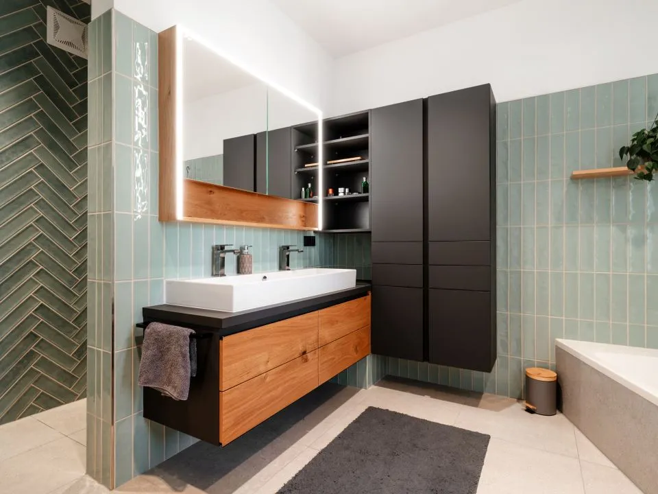 Badezimmer mit grünen Fliesen, Waschtisch und Badewanne