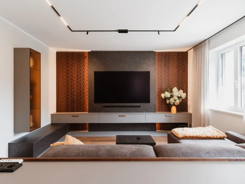 Wohnzimmer mit Medienwand, gemusterter Rückwand und Sofa