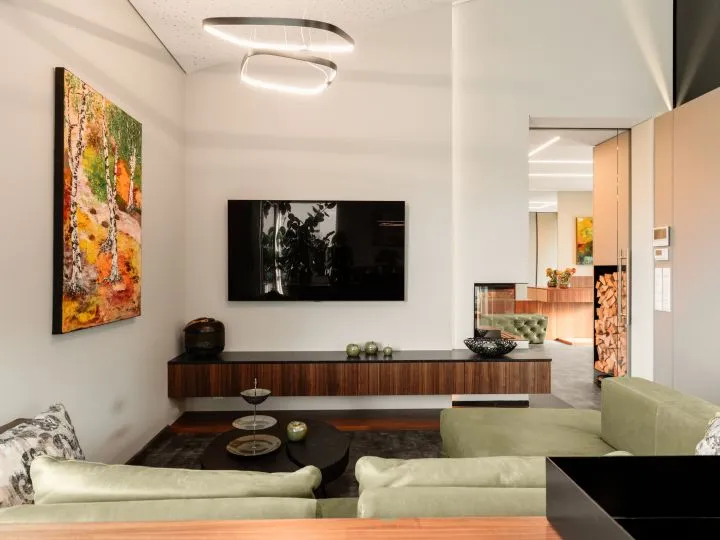 Wohnraum mit Sideboard, Fernseher und offenem Durchgang