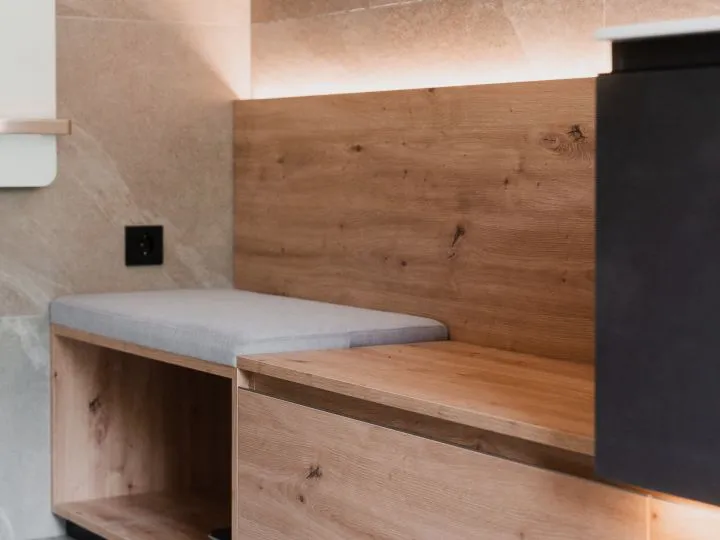 Detail einer gepolsterten Sitzbank vor einer Holzwand