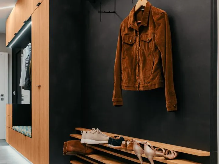 Garderobe mit dunkler Wandpaneele und aufgehängter Jacke