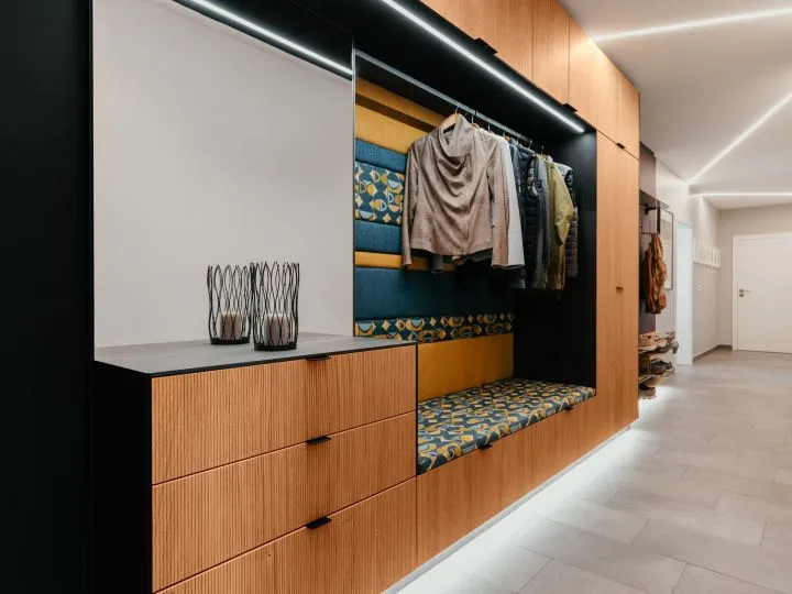 Begehbarer Kleiderschrank mit Holzfronten und Sitzbank