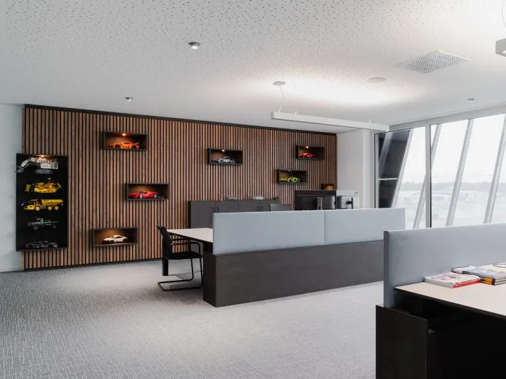 Empfangsbereich mit Holzlamellenwand und beleuchteten Vitrinen