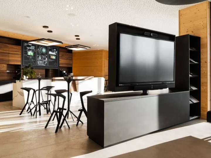 Bar- und Loungebereich mit Barhockern und Bildschirm