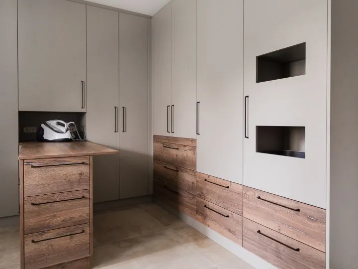 Hauswirtschaftsraum mit weißen Hochschränken und Arbeitsfläche in Holz