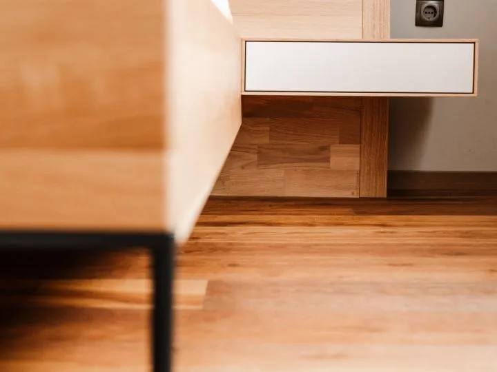 Detail einer Tischkante aus Holz über einem Holzboden