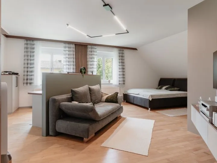 Schlafzimmer unter Dachschräge mit Sofa, Bett und Einbauschrank
