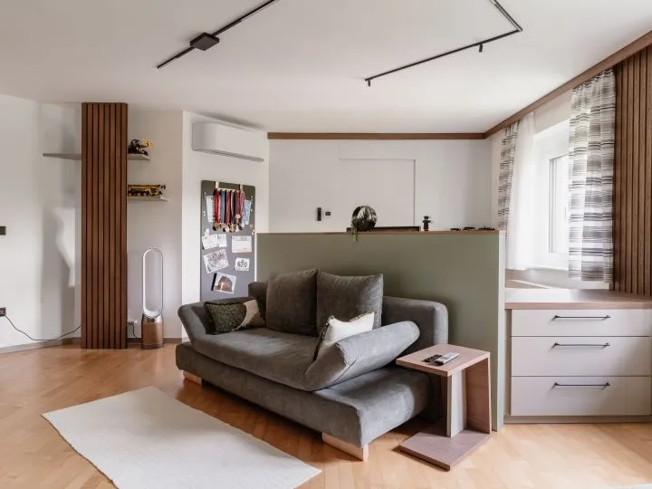 Wohnbereich mit Sofa, Holzsäule und weißem Sideboard