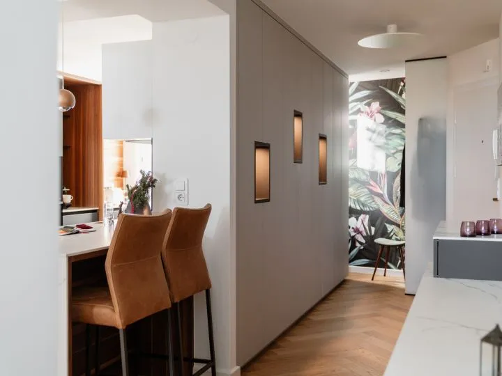 Arbeitsplatz mit Polstersessel, Wandleuchte und Raumteiler mit Blumenmotiv