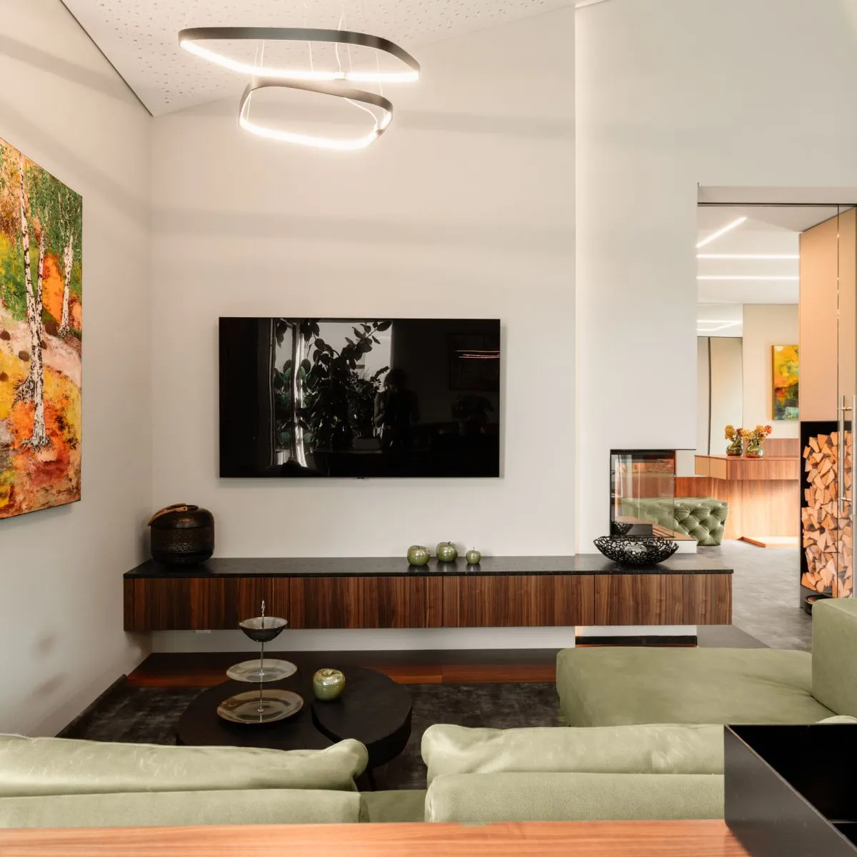 Wohnraum mit Sideboard, Fernseher und offenem Durchgang