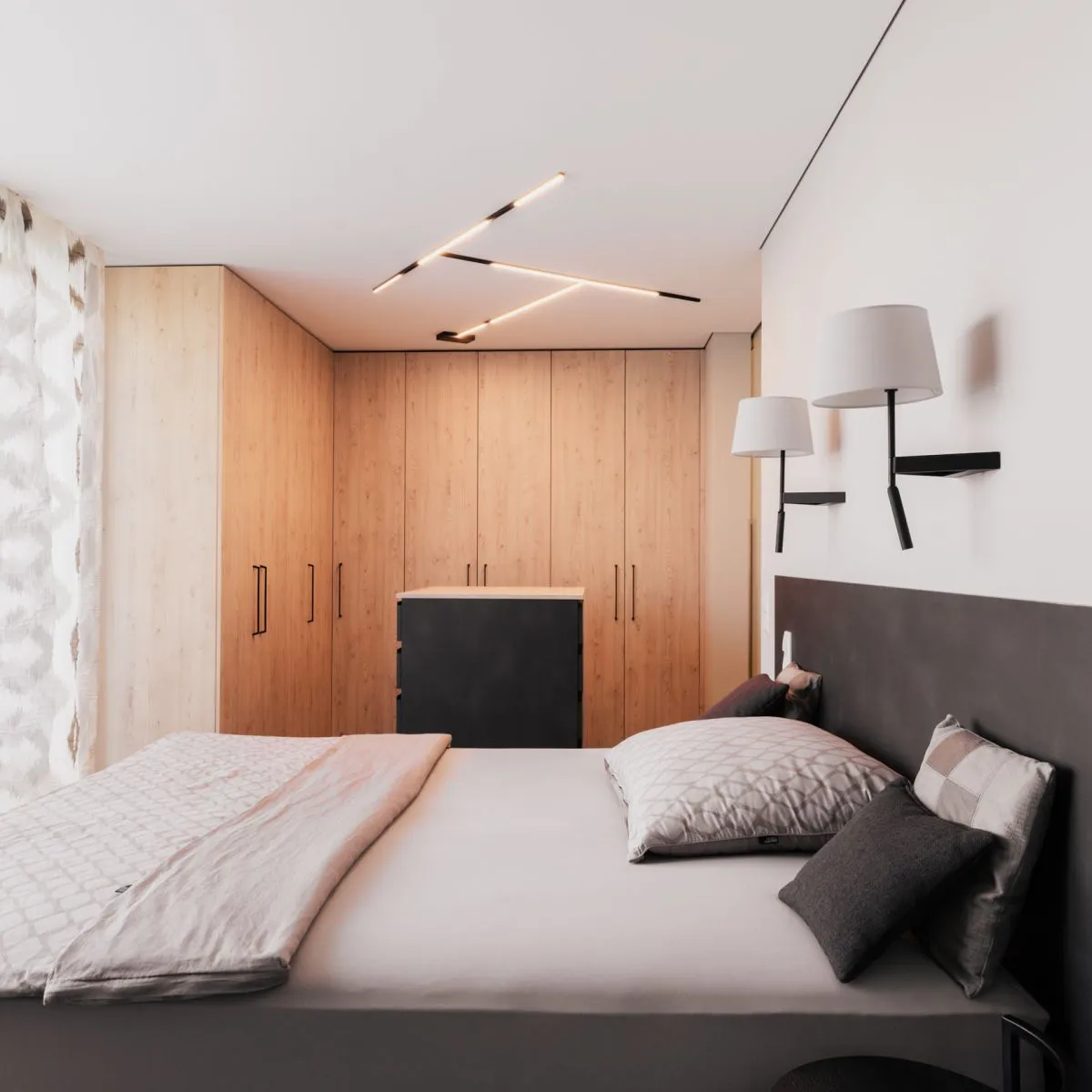 Schlafzimmer mit Holzschrank, Polsterbett und Wandleuchten