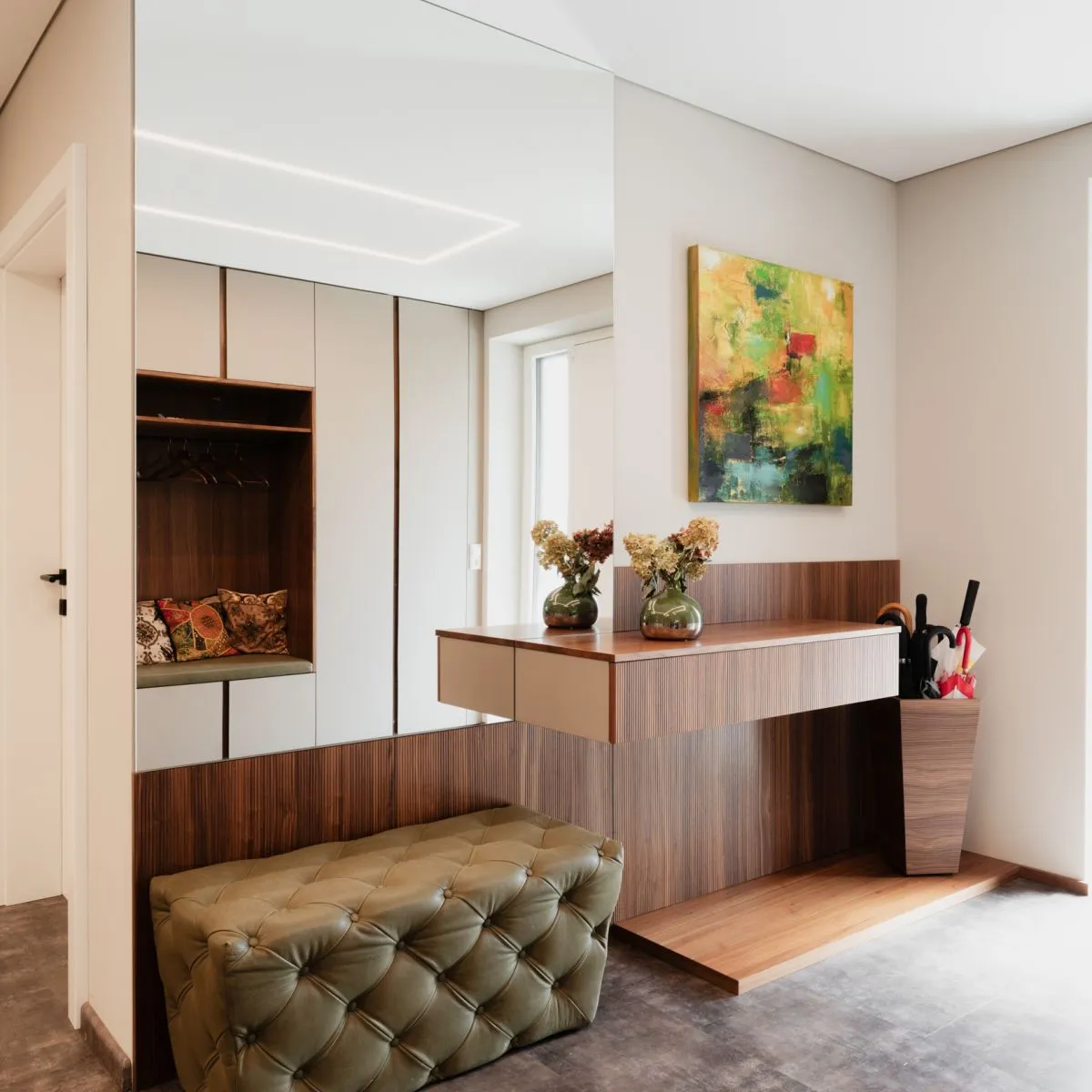 Vorzimmer mit Sideboard aus Holz, Trockenblumen und offener Garderobennische