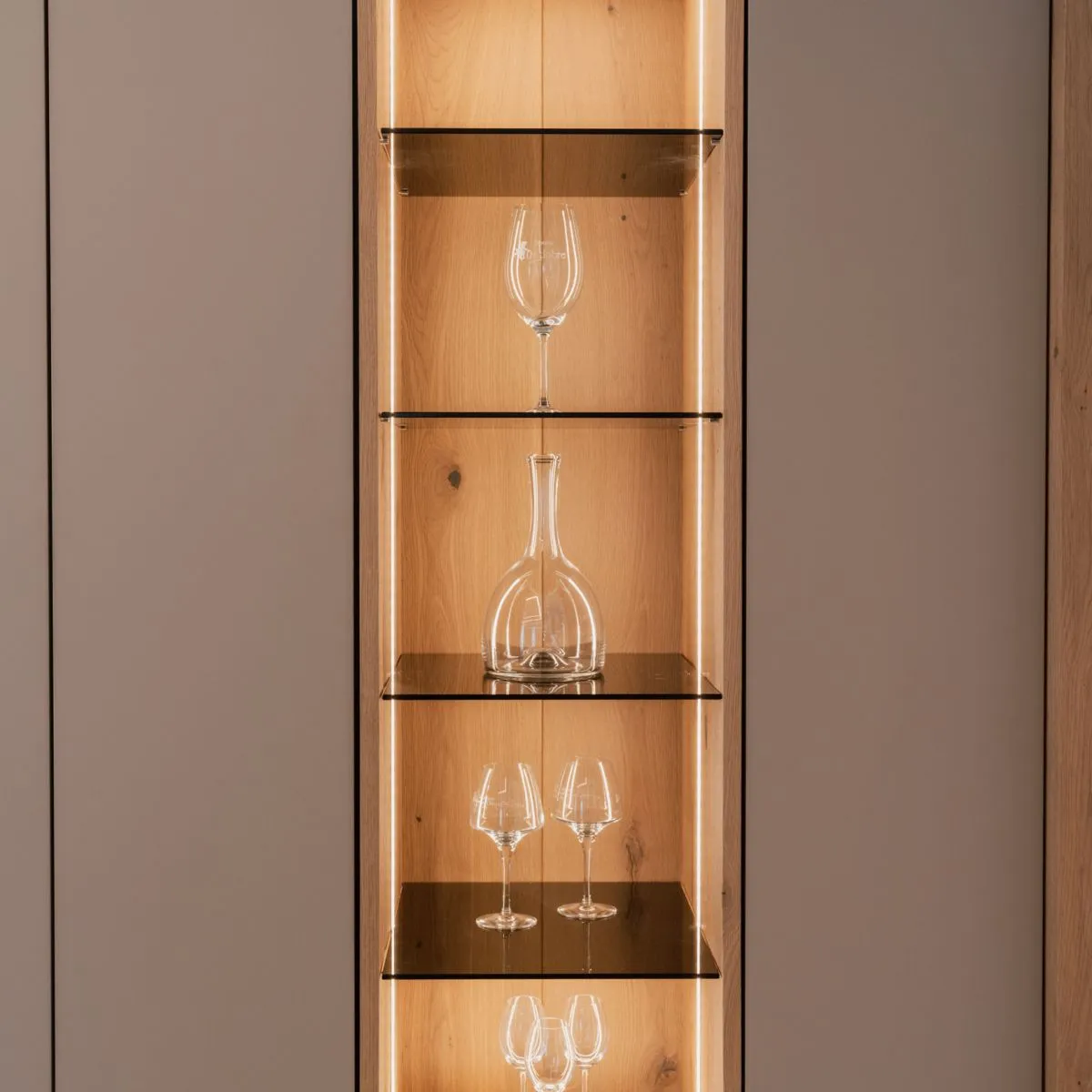 Beleuchtete Glasvitrine mit Karaffe zwischen matten Schrankfronten